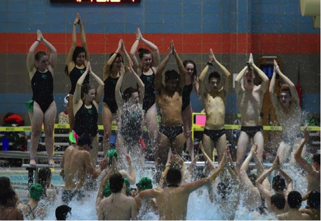 Swim team captains cheer with the team before starting their meet.
(Photo by Ken Sims)