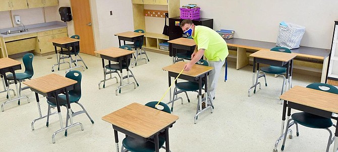 An FCPS employee prepares for socially distanced in-person school