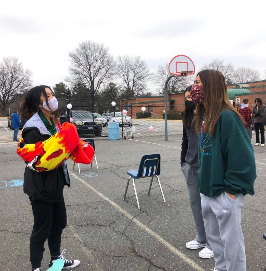 Seniors Christine Duong, Sophia Nguyen, and Kayla Nguyen attend a socially distanced senior event on the school basketball court.