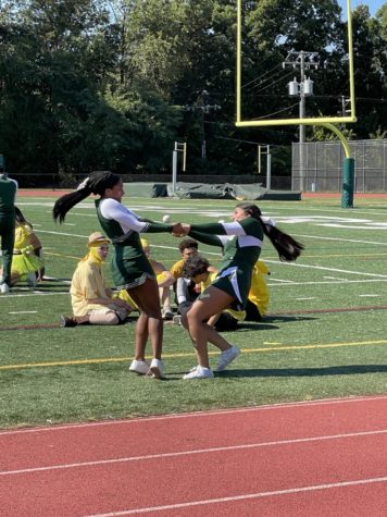 Two cheerleaders spin one another on the field.
