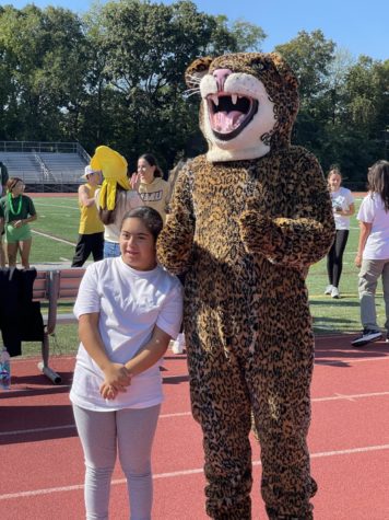 A student poses next to the mascot, a jaguar.