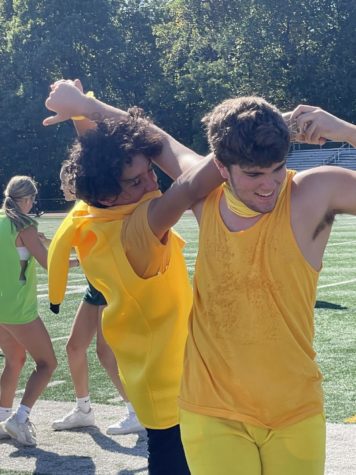 Two boys wearing yellow dance on the football field.