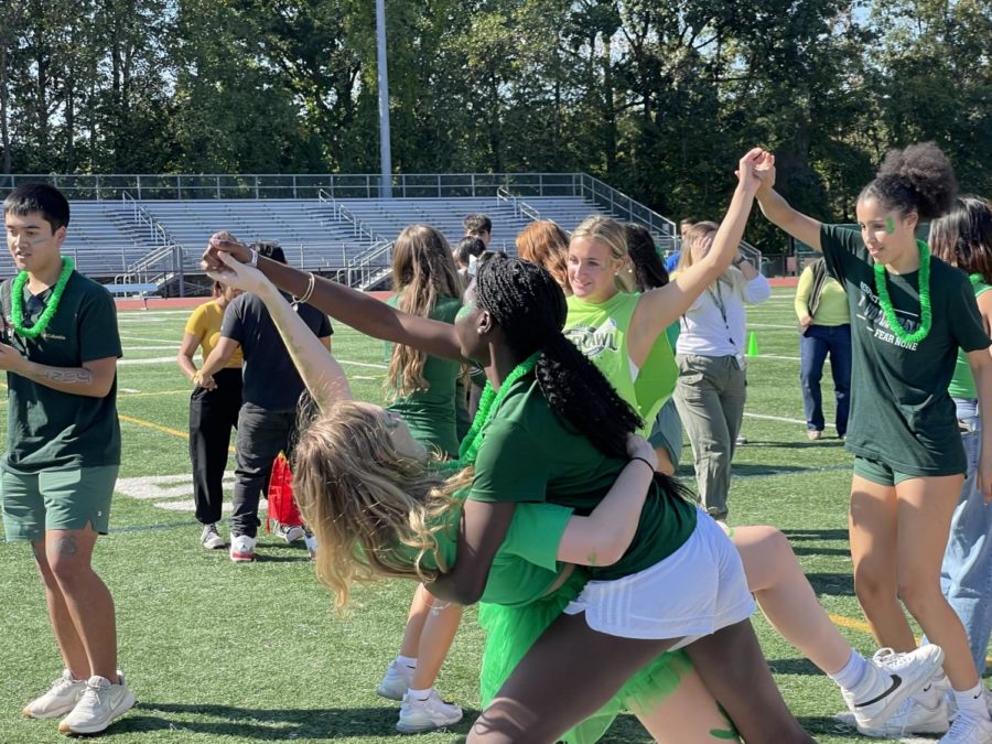 Students dancing on the football field during a pep rally.
