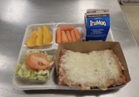 A photo of a school lunch tray with pizza, vegetables, and milk.