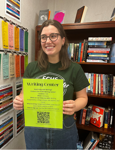Writing Center director Elizabeth Cymerman shows off the Writing Center flyer. Students can scan the QR code to make an appointment.