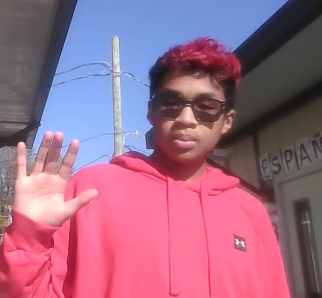 Elijah Holston waving, clad in his iconic shade of red. (Photo courtesy of Elijah Holston)