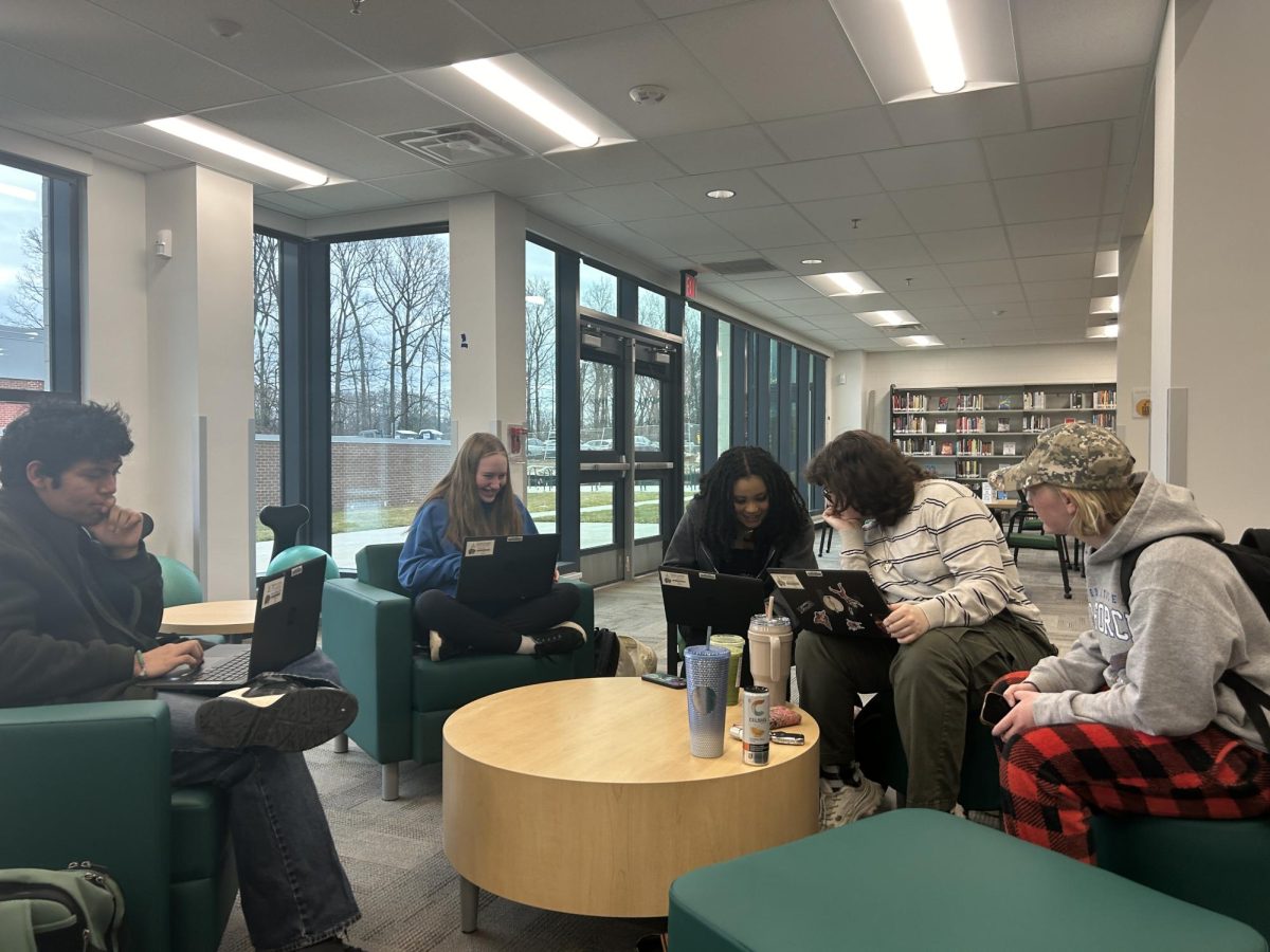 Benjamin Rodriguez-Chicas (11), Callie DeBoe (9), Caitlyn Baker (11), Ellis Mitchell (11), and Lauren Torres (11) converse about their academics in the new library. Standards-based grades can look different in SIS until students and parents get used to it.