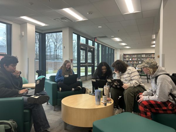 Benjamin Rodriguez-Chicas (11), Callie DeBoe (9), Caitlyn Baker (11), Ellis Mitchell (11), and Lauren Torres (11) converse about their academics in the new library. Standards-based grades can look different in SIS until students and parents get used to it.