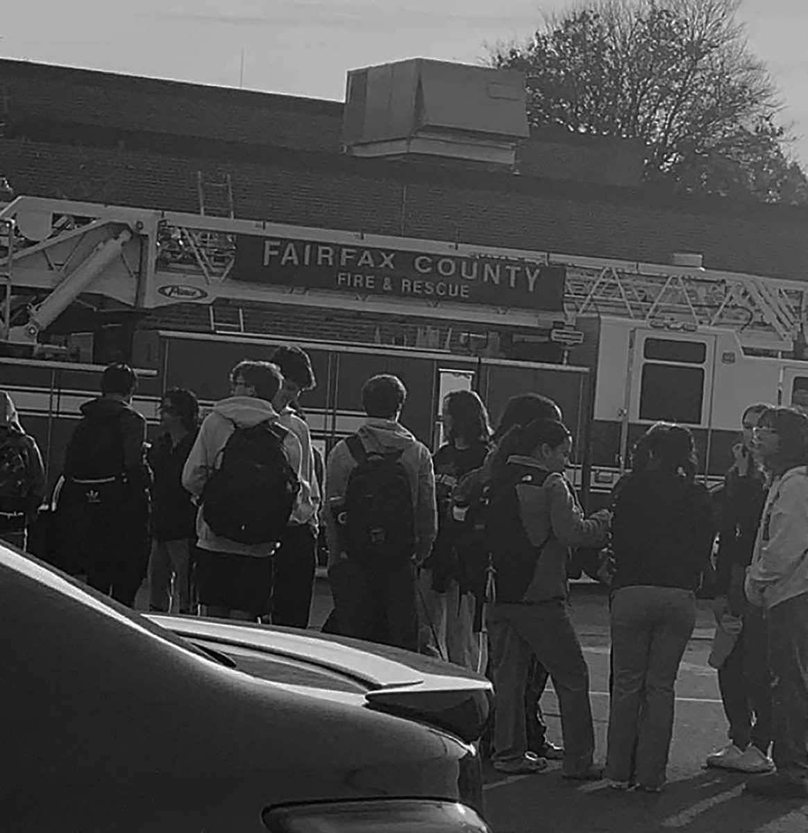 Students stand in the parking lot during an emergency evacuation due to a burning smell in the building. Fairfax County firefighters investigated and cleared students to return to the building.